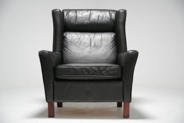 A Black Leather Winged Armchair.